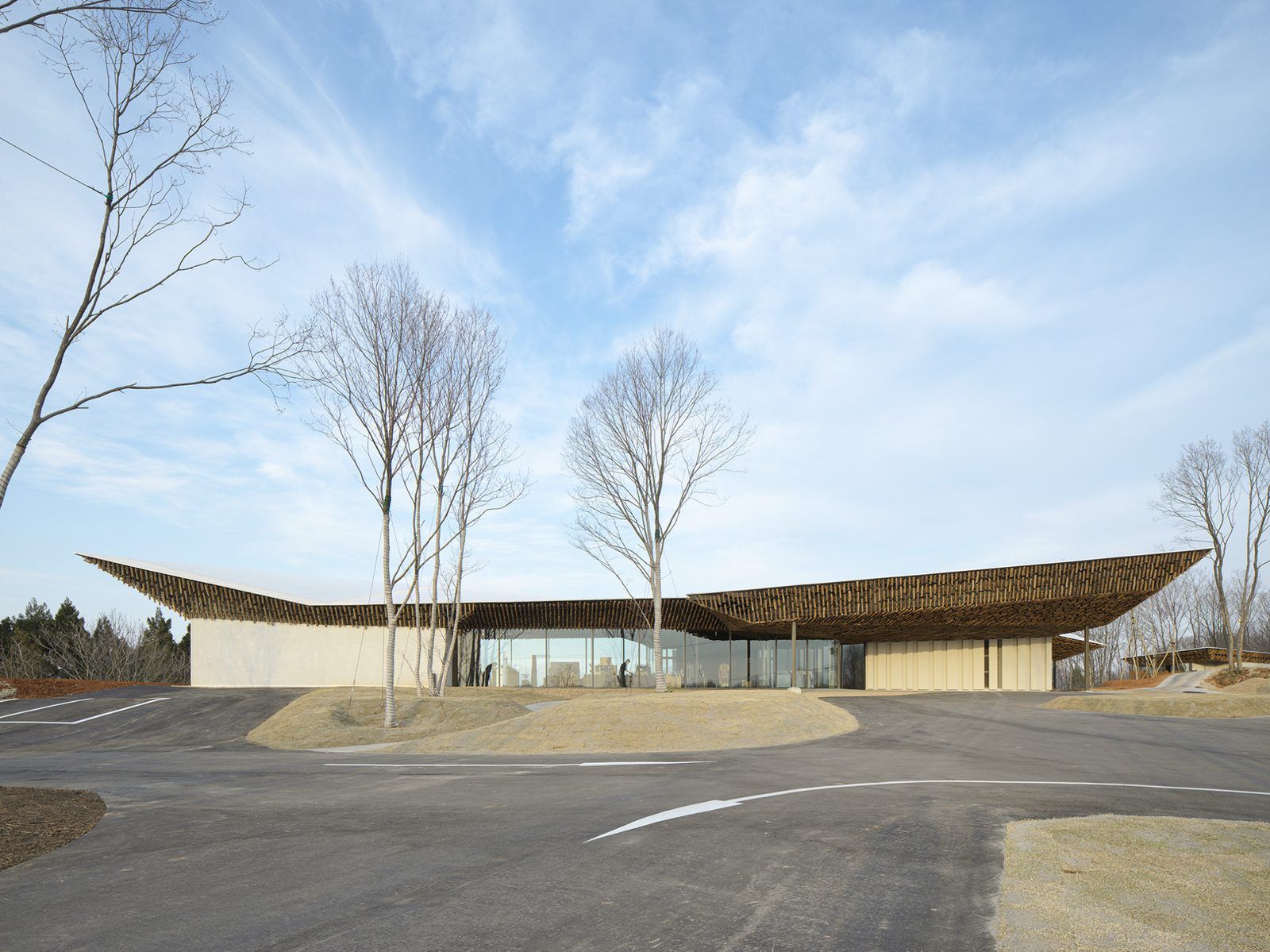 Ảnh 7 · FIELD SUITE SPA (Kengo Kuma, 2022): mái đơn dốc dài nương theo đường sống núi Awagatake phía sau; hiên ốp củi liền mạch trong–ngoài. Nguồn: KKAA